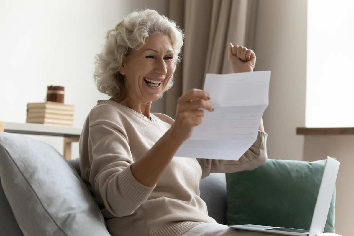 Excited woman getting good news holding paper